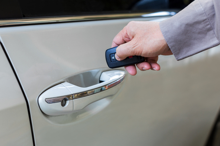 Male hand open the white car with keyless entry functionの写真素材