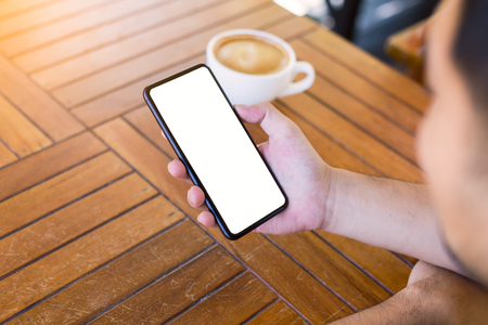 young man hands using smartphone for business in coffee shop with blank white screenの写真素材