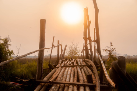 Old bamboo bridges over the river with sunset background.
