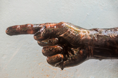Stain hands pointing with black oil on cement background.の写真素材