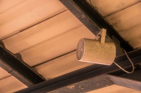 Old Loudspeaker hanging on the cement roof at station