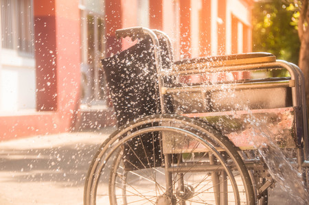 woman cleaning old wheelchair by   Water Splash,asian washing styleの写真素材