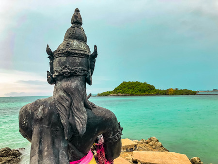 Phra Aphai Mani Statue on the stone reef off the coast with sea and blue skyの写真素材