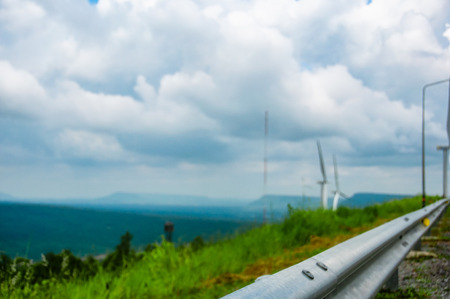 Railing at road side with wind turbines on mountain ,blue sky and cloud,Wind power station. Ecological energyの写真素材