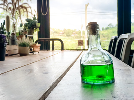 Green liquid in Glass bottles on wooden table at cafe,beverage drinkingの写真素材