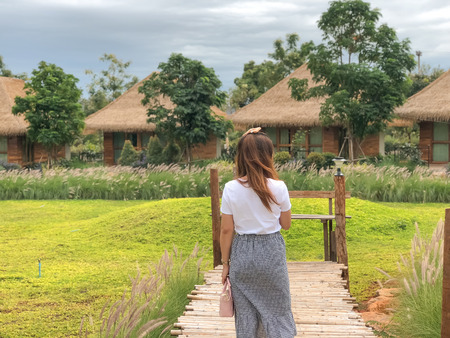 women on the wooden bridge way to the garden at resort