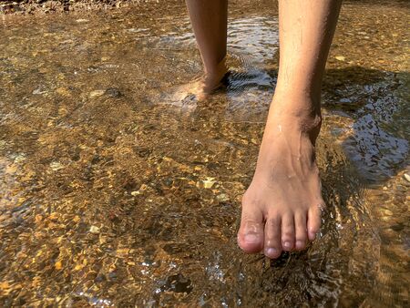 Woman leg in the water at waterfall,relax time with natureの写真素材