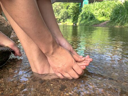 Woman leg in the water at waterfall,relax time with natureの写真素材