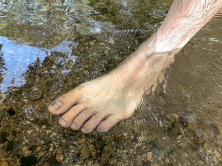 Woman leg in the water at waterfall,relax time with natureの写真素材