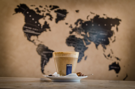 Cup of italian coffee Lavazza with map of the world in the backgroundの写真素材