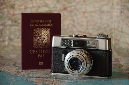 Old vintage analogue camera and passport on the map backgroundの写真素材