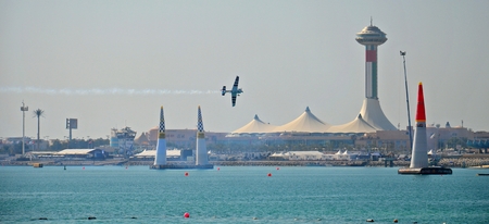 The plane is flying over the bay at Red Bull Air Race World Championship in Abu Dhabi, UAEのeditorial素材