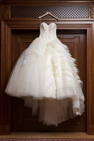 wedding dress hanging up by the windowの写真素材