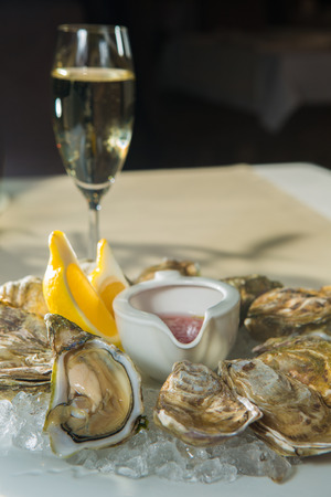 A platter of fresh organic raw oysters on ice at restaurantの写真素材