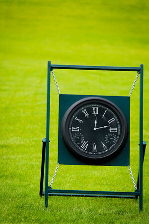 Clock on golf course with green spring valley on the backgroundの写真素材