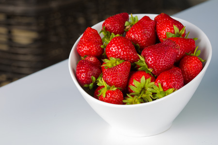 white bowl filled with succulent juicy fresh ripe red strawberriesの写真素材