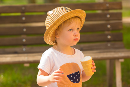 Cute Toddler Girl Eating Ice-Cream at park at backgroundの写真素材