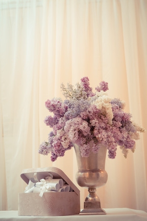 Lilac bouquet in a silver vase on the tableの写真素材