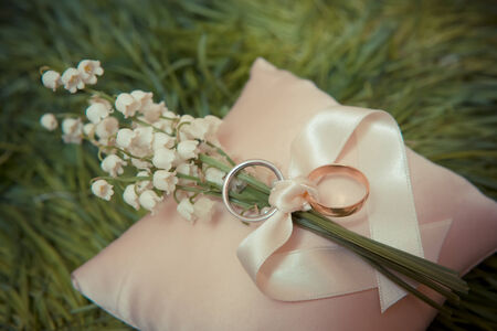 white gold wedding rings with a bouquet of lily of the Valleyの写真素材