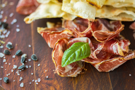 HomemHomemade prosciutto and basil on a wooden board in the Italian styleade prosciutto and basil on a wooden board in the Italian styleの写真素材
