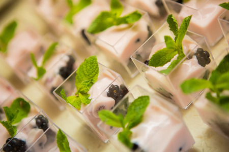 Layered dessert with fruits, nuts and cream cheese in glass jar, selective focusの写真素材