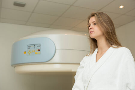 Happy woman undergoing open Magnetic resonance imaging scan.