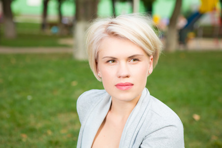 portrait of a beautiful blonde outdoors in the parkの写真素材