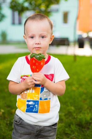 Boy with large lolipop in the parkの写真素材