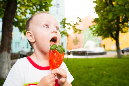 Boy with large lolipop in the parkの写真素材