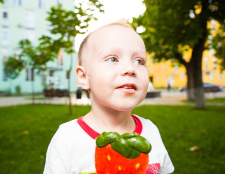 Boy with large lollipop in the parkの写真素材
