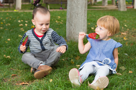 Adorable little girl and boy with colorful lollipopsの写真素材