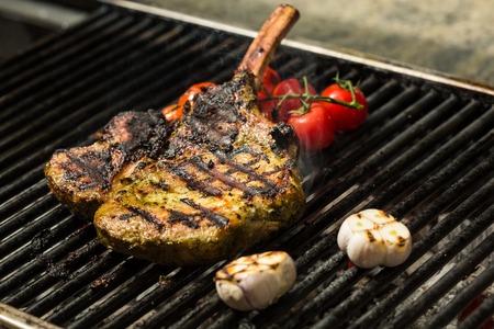 steak flame broiled on a barbecue with vegetables. shallow depth of field.の写真素材