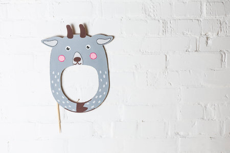 Bright cardboard mask on a white brick wall. Consept card. Goatの写真素材