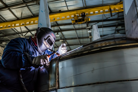 Man welding with reflection of sparks on visor. Hard job. Construction and manufacturingの写真素材