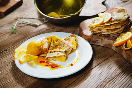 Dessert - stuffed pancakes with orange syrup and orange ice-creamの写真素材