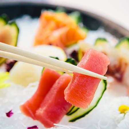 Tuna Sashimi - Maguro fresh raw tuna on Daikon White Radish. Garnished with Ginger, Wasabi, Seaweed, Cucumber, Salad Leaf and Lemonの写真素材