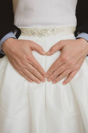 Elegant bride and groom posing together in studio on a wedding dayの写真素材