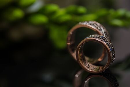 Two wedding rings in infinity sign with bouquet on black background. Love concept.の写真素材