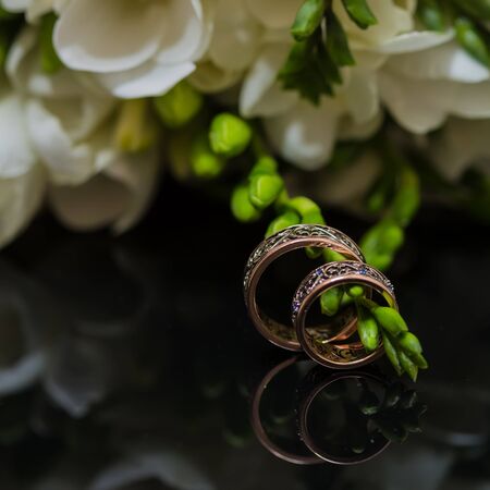 Two wedding rings in infinity sign with bouquet on black background. Love concept.の写真素材