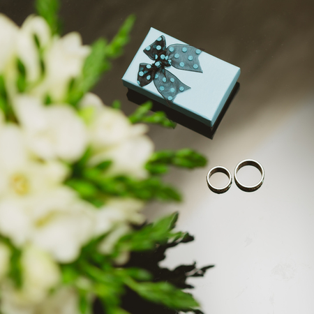 Two wedding rings in infinity sign with bouquet on black background. Love concept.の写真素材