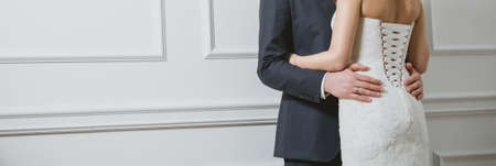 Elegant bride and groom posing together in studio on a wedding dayの写真素材