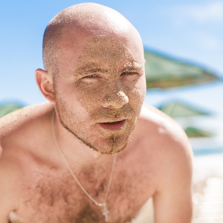 Half face of a handsome man covered with sand. Bulgaria, Black Seaの写真素材