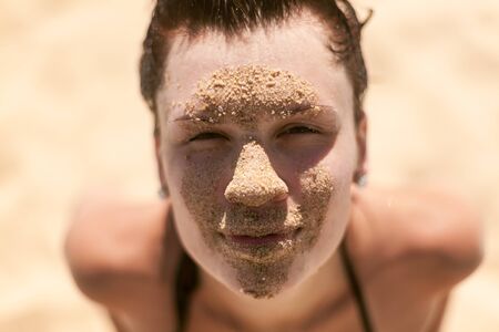 Beautiful girl portrait with sand on faceの写真素材
