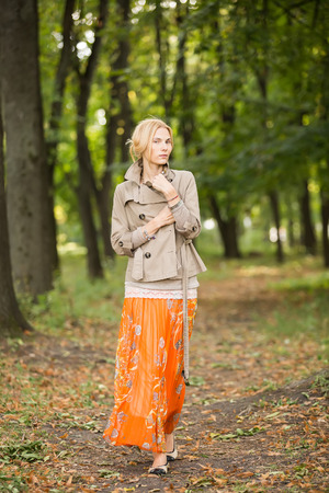 Young fashionable woman walking in spring parkの写真素材