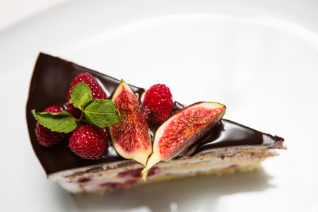 cake with chocolate, fig and raspberry decorated mint leavesの写真素材