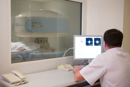 doctor analyzing results of woman patient at bone densitometer machine.の写真素材