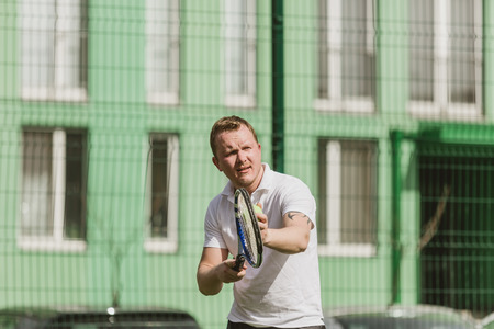 young man play tennis outdoor on tennis field at early morningの写真素材