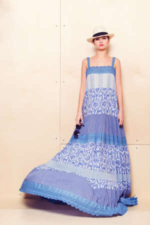 Full-length portrait of a lovely woman in romantic dress on wodden backgroundの写真素材