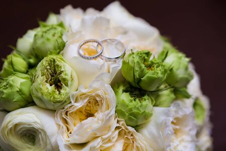 Bouquet of white roses and silver wedding ringsの写真素材