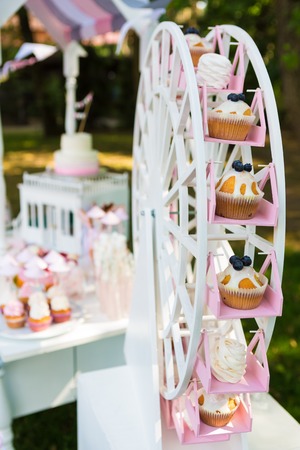 Dessert table for a party. Cake, cupcakes, sweetness and flowers. Shallow dofの写真素材